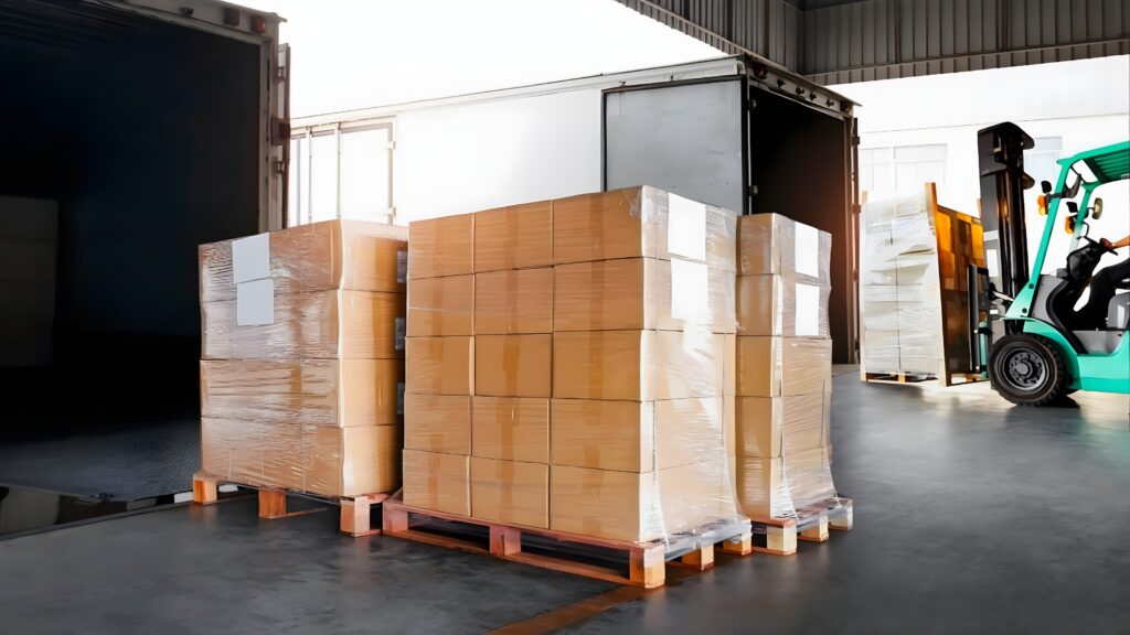 Warehouse worker moving boxes with a pallet jack, demonstrating the process of LTL shipping.