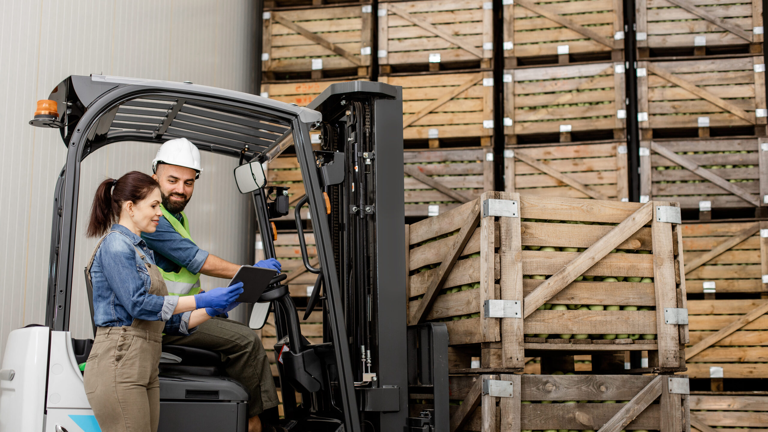 Logistics company workers managing the loading of products with modern equipment in a warehouse.