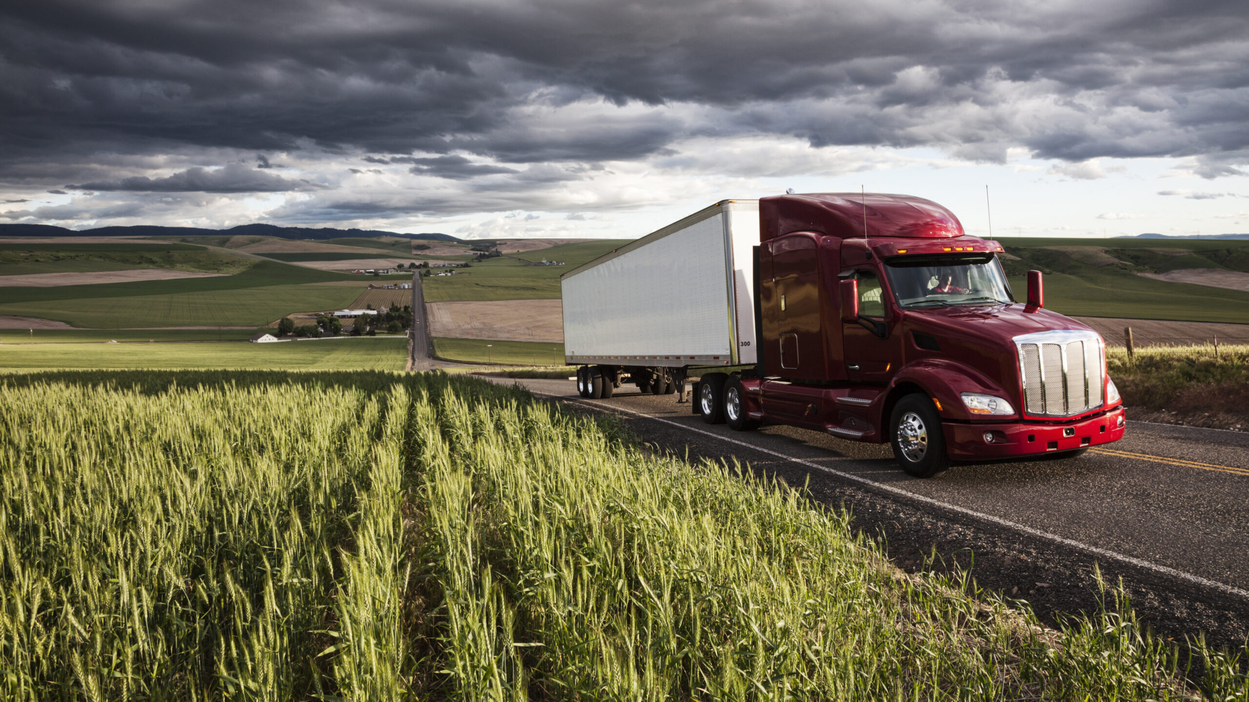 Commercial truck driving through fields as part of cross-border logistics operations