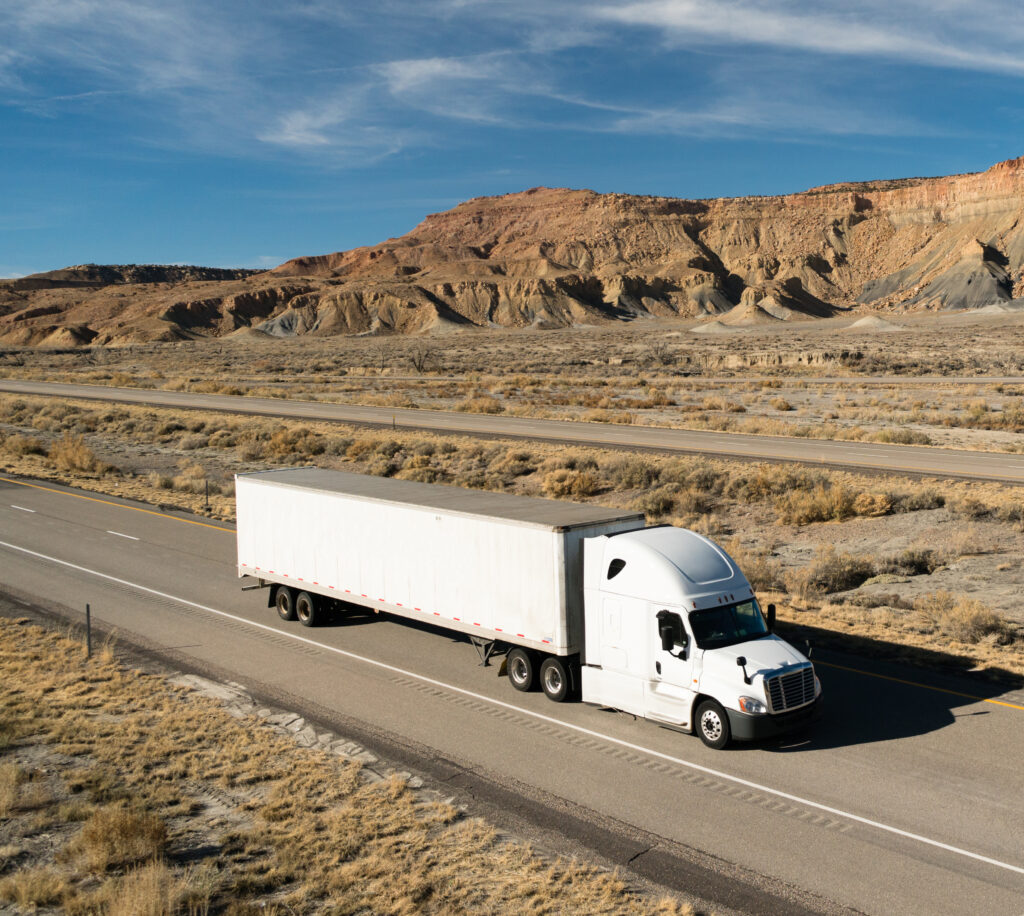 Cross-border shipping truck on a U.S. highway, transporting goods with an 18-wheeler semi-truck